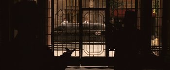Movie still from “Vantage Point” (2008), directed by Pete Travis – A cat sitting on the ground in front of a building; Extreme Wide shot, Over the shoulder angle