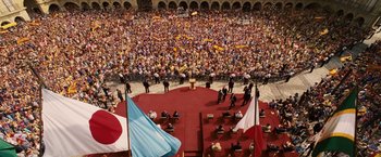 Movie still from “Vantage Point” (2008), directed by Pete Travis – A large crowd of people are gathered in an arena; Extreme Wide shot, High angle