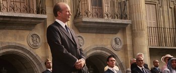 Movie still from “Vantage Point” (2008), directed by Pete Travis – A man in a suit standing next to another man in a suit; Medium shot, Low angle