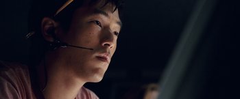 Movie still from “Vantage Point” (2008), directed by Pete Travis – A man with a headset on looking at a computer screen; Close Up shot, Over the shoulder angle