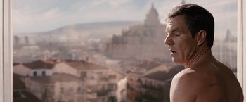 Movie still from “Vantage Point” (2008), directed by Pete Travis – A man standing in front of a large city; Close Up shot, Low angle
