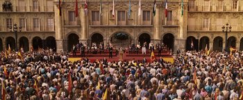 Movie still from “Vantage Point” (2008), directed by Pete Travis – A crowd of people sitting in front of a building; Extreme Wide shot, High angle