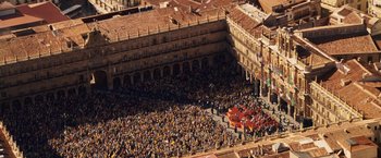 Movie still from “Vantage Point” (2008), directed by Pete Travis – An aerial view of a large crowd of people in an open area; Extreme Wide shot, High angle