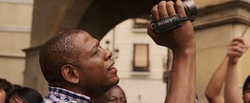 Movie still from “Vantage Point” (2008), directed by Pete Travis – A man taking a picture with a sony camera; Close Up shot, Low angle