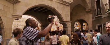 Movie still from “Vantage Point” (2008), directed by Pete Travis – A man taking a picture with a cell phone; Medium shot, Low angle