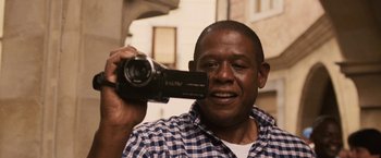 Movie still from “Vantage Point” (2008), directed by Pete Travis – A person holding a video camera; Close Up shot, Low angle