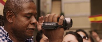Movie still from “Vantage Point” (2008), directed by Pete Travis – A man holding a camera up to his face; Close Up shot, Low angle