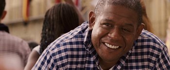 Movie still from “Vantage Point” (2008), directed by Pete Travis – A person wearing a plaid shirt smiling; Close Up shot, Over the shoulder angle