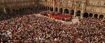 Movie still from “Vantage Point” (2008), directed by Pete Travis – A crowd of people sitting in front of a stage; Extreme Wide shot, High angle