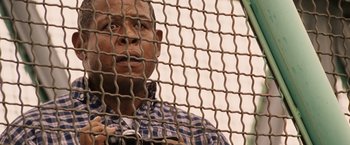 Movie still from “Vantage Point” (2008), directed by Pete Travis – A person behind a chain link fence; Close Up shot, Over the shoulder angle