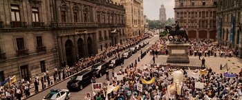 Movie still from “Vantage Point” (2008), directed by Pete Travis – A large crowd of people on a street with cars; Extreme Wide shot, High angle