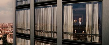 Movie still from “Vantage Point” (2008), directed by Pete Travis – A view of a room through a window with curtains on it; Medium shot, Low angle