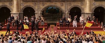 Movie still from “Vantage Point” (2008), directed by Pete Travis – A large crowd of people are gathered in front of a building; Extreme Wide shot, High angle