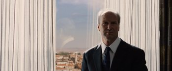 Movie still from “Vantage Point” (2008), directed by Pete Travis – A man in a suit and tie standing in front of a window; Close Up shot, Low angle