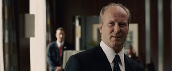 Movie still from “Vantage Point” (2008), directed by Pete Travis – A man in a suit and tie standing in front of another man; Close Up shot, Over the shoulder angle