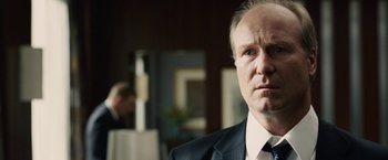 Movie still from “Vantage Point” (2008), directed by Pete Travis – A man in a suit and tie looking at the camera; Close Up shot, Over the shoulder angle