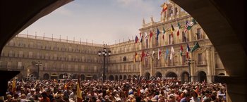 Movie still from “Vantage Point” (2008), directed by Pete Travis – A crowd of people gathered in front of a large building; Extreme Wide shot, High angle