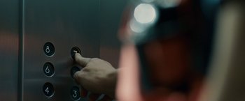 Movie still from “Vantage Point” (2008), directed by Pete Travis – A person is holding a handle on a lift; Extreme Close Up shot, Overhead angle