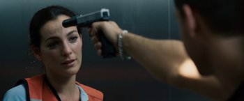Movie still from “Vantage Point” (2008), directed by Pete Travis – A woman in an orange jacket holding a gun; Close Up shot, Over the shoulder angle