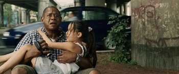 Movie still from “Vantage Point” (2008), directed by Pete Travis – An older man holding a little girl in his arms; Medium shot, Over the shoulder angle