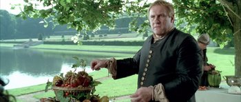 Movie still from “Vatel” (2000), directed by Roland Joffé – A man standing in front of a bowl of fruit; Medium shot, Low angle