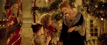 Movie still from “Vatel” (2000), directed by Roland Joffé – Two women and a little girl standing in front of a christmas tree; Medium shot, Over the shoulder angle