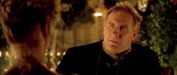 Movie still from “Vatel” (2000), directed by Roland Joffé – A person wearing a suit and tie; Close Up shot, Over the shoulder angle