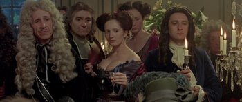 Movie still from “Vatel” (2000), directed by Roland Joffé – A group of people standing around a woman; Medium shot, Over the shoulder angle