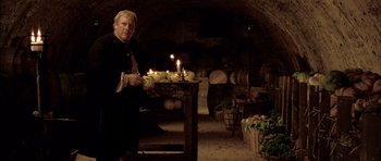 Movie still from “Vatel” (2000), directed by Roland Joffé – A man standing next to a table with candles on top of it; Medium shot, Low angle