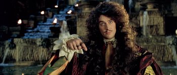 Movie still from “Vatel” (2000), directed by Roland Joffé – A man with a long curly black hair and a mustache; Close Up shot, Over the shoulder angle