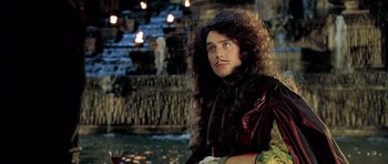 Movie still from “Vatel” (2000), directed by Roland Joffé – A man with long curly brown hair wearing a wig; Medium shot, High angle
