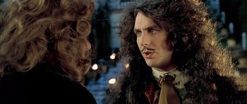 Movie still from “Vatel” (2000), directed by Roland Joffé – A man with long curly hair is talking to another man; Close Up shot, Over the shoulder angle