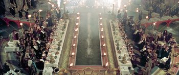 Movie still from “Vatel” (2000), directed by Roland Joffé – A large banquet hall with a fountain and a large table with many candles on it; Extreme Wide shot, Overhead angle
