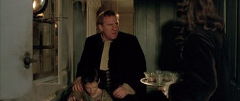 Movie still from “Vatel” (2000), directed by Roland Joffé – A man standing next to another man in a room; Medium shot, Low angle