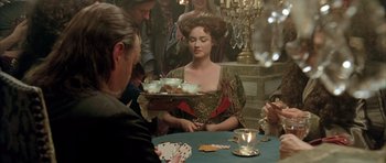 Movie still from “Vatel” (2000), directed by Roland Joffé – A group of people sitting around a table with food; Medium shot, Over the shoulder angle