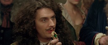 Movie still from “Vatel” (2000), directed by Roland Joffé – A man with a long curly hair and a mustache holding a ring; Close Up shot, Over the shoulder angle