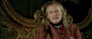 Movie still from “Vatel” (2000), directed by Roland Joffé – An older man with long hair and a mustache; Close Up shot, Low angle