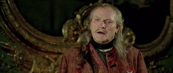 Movie still from “Vatel” (2000), directed by Roland Joffé – An older man with long hair and a beard; Close Up shot, Over the shoulder angle