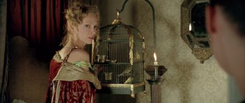 Movie still from “Vatel” (2000), directed by Roland Joffé – A woman standing in front of a bird in a cage; Medium shot, Low angle
