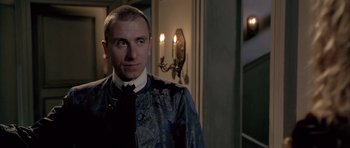 Movie still from “Vatel” (2000), directed by Roland Joffé – A man standing in front of a wall with candles on the wall; Close Up shot, Over the shoulder angle