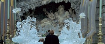 Movie still from “Vatel” (2000), directed by Roland Joffé – A man standing in front of an ice sculpture of neptune; Wide shot, Over the shoulder angle