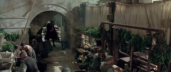 Movie still from “Vatel” (2000), directed by Roland Joffé – A group of people sitting around a vegetable stand; Wide shot, High angle