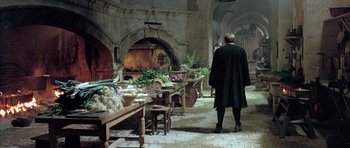 Movie still from “Vatel” (2000), directed by Roland Joffé – A man standing in front of an oven filled with food; Wide shot, High angle