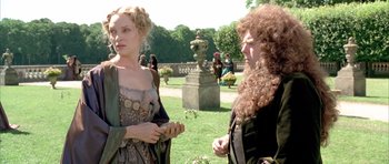 Movie still from “Vatel” (2000), directed by Roland Joffé – Two women are standing in a park talking to each other; Medium shot, Over the shoulder angle
