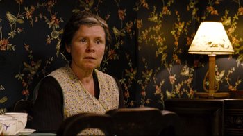 Movie still from “Vera Drake” (2004), directed by Mike Leigh – An older woman sitting in front of a mirror; Medium shot, Low angle
