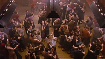 Movie still from “Vera Drake” (2004), directed by Mike Leigh – An overhead view of a crowd of people dancing; Extreme Wide shot, High angle