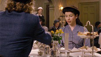 Movie still from “Vera Drake” (2004), directed by Mike Leigh – A group of people sitting around a table; Medium shot, Over the shoulder angle
