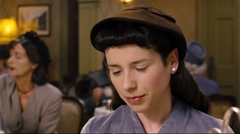 Movie still from “Vera Drake” (2004), directed by Mike Leigh – A woman with a hat on looking down at her face; Close Up shot, Over the shoulder angle