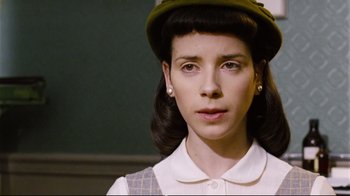 Movie still from “Vera Drake” (2004), directed by Mike Leigh – A young woman wearing a green hat and a white shirt; Close Up shot, Low angle