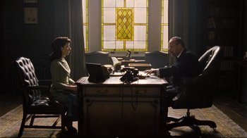 Movie still from “Vera Drake” (2004), directed by Mike Leigh – A man and a woman sitting in front of a computer; Medium shot, Low angle